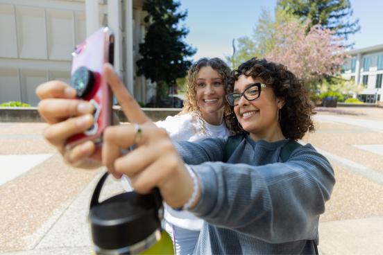 Two students taking a photo on a camera