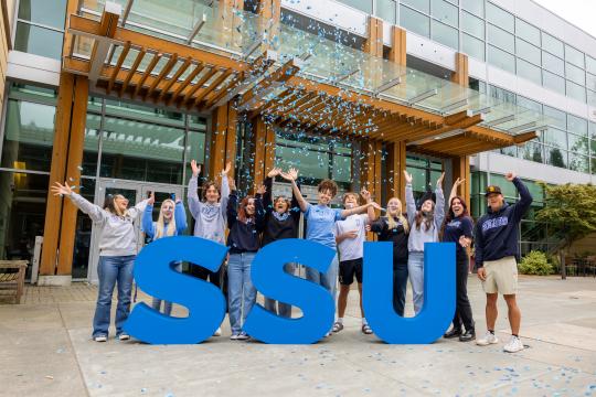 SSU large letters with group of students standing behind cheering and confetti in the air